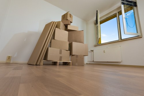 Professional movers carrying furniture through a London home entrance